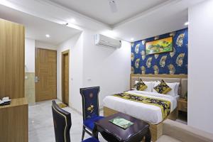 新德里的住宿－Hotel Decent Aerocity - Mahipalpur, Delhi Airport，酒店客房配有一张床铺、一张桌子和一张书桌。