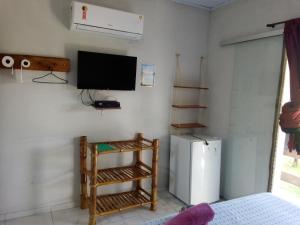 Habitación con nevera y TV en la pared. en Pousada Acuípe en Olivença