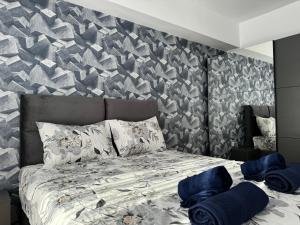 Un dormitorio con una cama con toallas azules. en East Gate Luxury Apartment, en Skopje