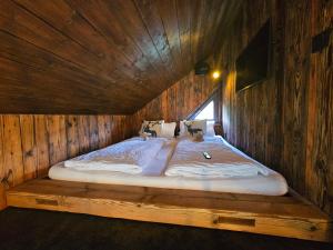 a bedroom with a large bed in a wooden room at Baumhaus Heuhütte in Salem