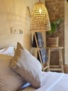 a bedroom with a bed with a pillow and a lamp at Sugar Hostel Weligama - Coliving & Coworking in Weligama