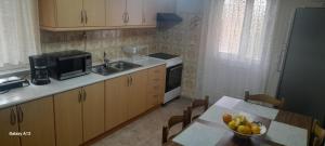 a kitchen with a sink and a table with a bowl of fruit at Fotini's House Sweet Dreams in Pentati