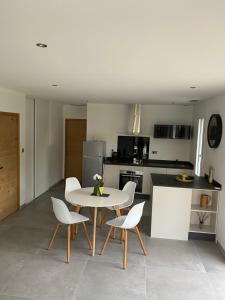 a kitchen with a table and chairs in a room at Maison calme IHESA in Bidache