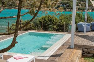 einen Pool mit Blick auf das Wasser in der Unterkunft Villa SEA SOUL - Luxury style with direct access to sea in Porto Taverna