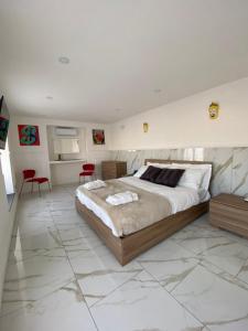 Schlafzimmer mit einem großen Bett mit weißen Wänden und Marmorböden in der Unterkunft PIPPO'S SUITE in Neapel