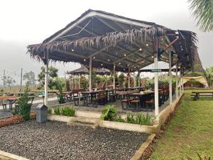 a pavilion with tables and benches in a park at Buana Glamping in Pengalengan