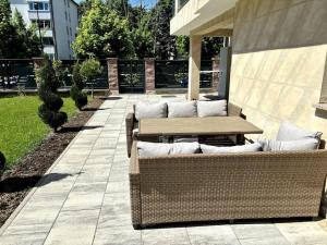 a patio with two wicker chairs and a wooden table at Villa Moste 5 -with pool&parking in Ljubljana