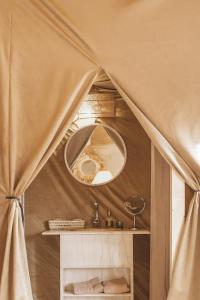 La salle de bains est pourvue d'un miroir et d'un lavabo dans une tente. dans l'établissement Caravanserai Luxury Desert Camp, à Merzouga