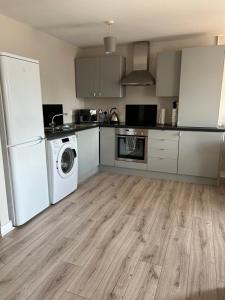 a kitchen with a refrigerator and a washer and dryer at Slane Stay, Belfast in Belfast