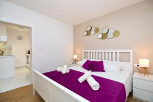 a bedroom with a large bed with purple sheets and pillows at GOLDEN ROSE - walking distance 1 km from old town in Dubrovnik