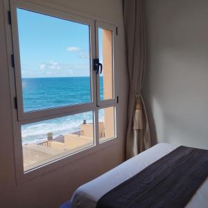 a bedroom with a window with a view of the ocean at Facing the ocean in Santa Maria de Guia de Gran Canaria