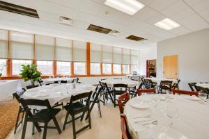 a room with white tables and chairs and windows at 1 Mi to Allegheny River Cozy Apt with Shared Patio! in New Kensington +25 photos