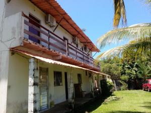 une vieille maison avec un palmier en face dans l'établissement Pousada Acuípe, à Olivença