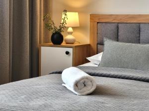 - une chambre avec un lit et une serviette blanche dans l'établissement Apartamenty Velvet, à Kościelisko