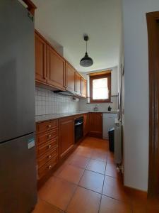 a kitchen with wooden cabinets and a tile floor at Ca de Mariona en Boí apartamento con terraza in Bohí