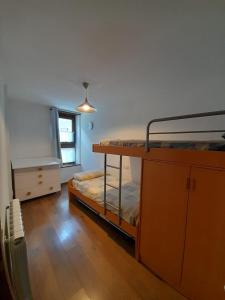 a bedroom with bunk beds and a dresser and a window at Ca de Mariona en Boí apartamento con terraza in Bohí