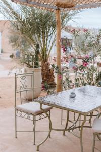 einen Tisch und zwei Stühle sowie einen Tisch und einen Tisch in der Unterkunft Caravanserai Luxury Desert Camp in Merzouga