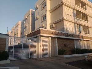 a large white building with a sign on it at Apartamento em Uruguaiana in Uruguaiana