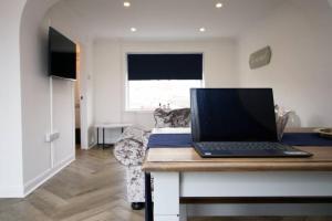 laptopa siedzącego na biurku w pokoju w obiekcie Beachfront Home with Ocean View w mieście Port Talbot