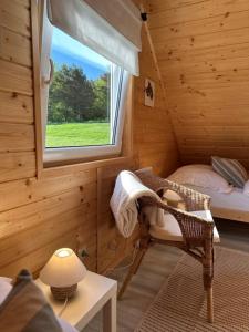 een kamer met een bed en een raam in een hut bij Domki w Potokach in Bóbrka