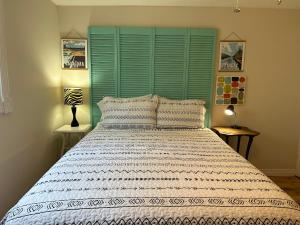 a bedroom with a large bed with a green headboard at Modern Beach House long stay discounts in Sarnia