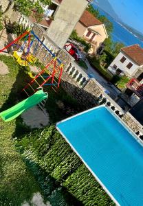 an aerial view of a pool with a slide and a playground at Family House with pool & sea view in Bijela