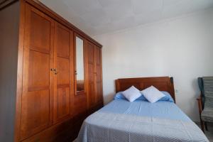 a bedroom with a bed and a wooden cabinet at Vivienda Unifamiliar 500 m cuadrados in Isla Cristina