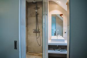 een badkamer met een douche en een wastafel bij Hotel Les Eleveurs in Halle