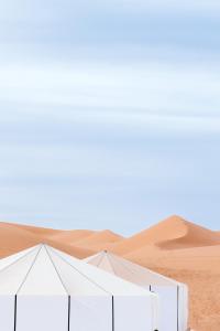 Eine Wüste mit zwei Zelten im Sand in der Unterkunft Caravanserai Luxury Desert Camp in Merzouga