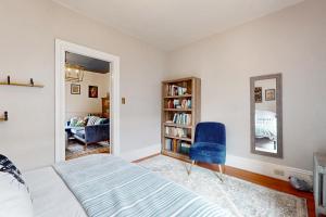 塞勒姆的住宿－Witchy Modern，一间卧室配有一张床和一张蓝色椅子