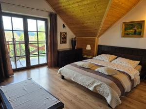 1 dormitorio con cama grande y ventana grande en Grzechowisko, en Wetlina
