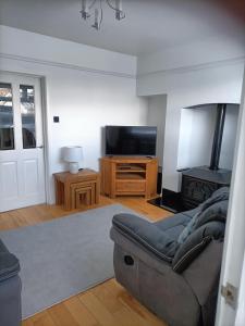 a living room with a couch and a flat screen tv at Mill cottage in Carrickfergus