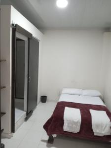 1 dormitorio blanco con 1 cama con manta roja en Hostal cafe casa de la abuela, en Santa Rosa de Cabal