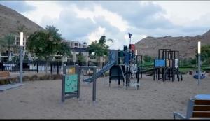 een speeltuin met een glijbaan in het zand bij خليج مسقط in Qantab