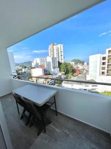 een tafel op een balkon met uitzicht op de stad bij Loft de lujo,Vista panorámica in Manizales