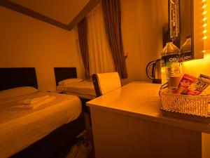 Habitación de hotel con 2 camas y barra con mesa en Ezel Group, en Antalya