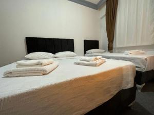Dos camas en una habitación con toallas. en Ezel Group, en Antalya