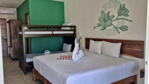 a bedroom with a bed and bunk beds with a chess board at Hotel Sonno Caliza Tulum in Tulum