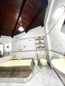 a bathroom with a tub and a toilet and a sink at Gaby’s Home. in Quito