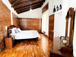 a bedroom with a white bed and a brick wall at Gaby’s Home. in Quito