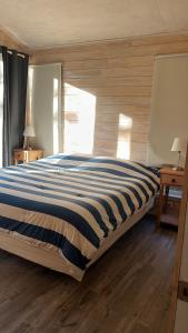 a bedroom with a large bed with a striped blanket at QUELEN PATAGONIA in Villa Cerro Castillo