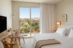 um quarto com uma cama, uma mesa e uma janela em Pátio do Tijolo em Lisboa