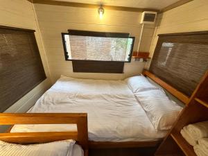CozyVan Каравана под Наем في سوزوبول: غرفة نوم صغيرة بها سرير ونافذة