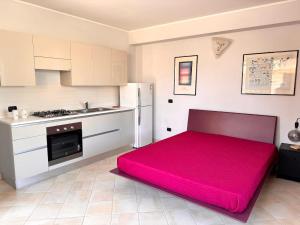 - une cuisine avec un grand lit rouge dans une chambre dans l'établissement Oasi del Sole - Marzamemi, à Marzamemi