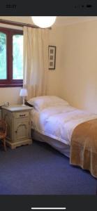 1 dormitorio con cama, mesa y ventana en Craigie dhu, golf haven, en Colliston