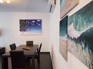une salle à manger avec une table, des chaises et des peintures dans l'établissement "Beach Apartment over the Sea" - I, à Albufeira