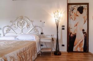 ein Schlafzimmer mit einem Bett, einer Lampe und einem Tisch in der Unterkunft Manuela Le Quattro Coppe in Desenzano del Garda