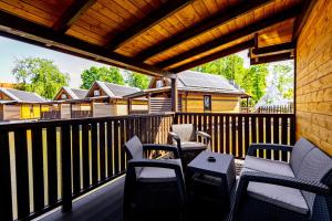 a patio with chairs and a table on a deck at Western Camp Resort in Zator