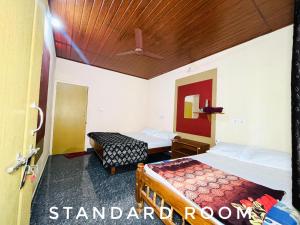 a room with two beds and a room with a door at Isiri river side stay in Kalasa