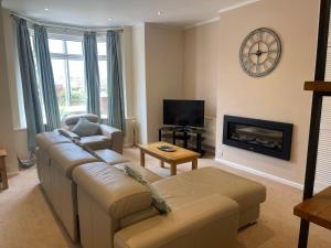a living room with a couch and a fireplace at Belle-Vue Apartments in Hunstanton